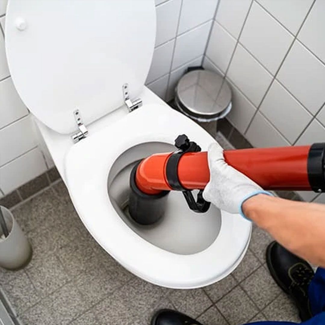 Vakkundige loodgieter aan het werk met ontstoppingsgereedschap